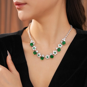 Luxurious flower necklace with emerald green crystals and white zircons on model