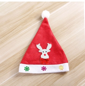 Détail du bonnet de Noël rouge avec applique de renne en peluche et broderie de flocon