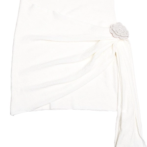 Detaillierte Nahaufnahme von weißem Strickstoff mit einer beige Häkelblume Akzent