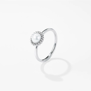 Macro detail of silver pearl ring with minimalist bead setting and vintage finish