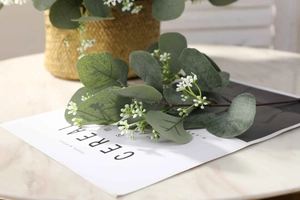 Detailed view of artificial eucalyptus branches with grey-green leaves and small white flowers