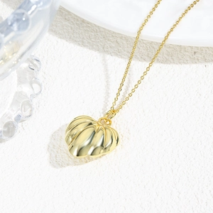 Macro shot of 18k gold plated hollow heart pendant with textured surface and fine chain