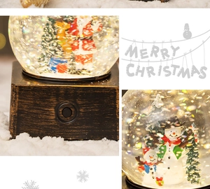 Detail of Christmas snow globe showing Santa scenes and metallic base with functional switch