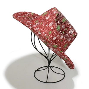 Detail of red glitter Christmas cowboy hat with snowflake patterns on a black metal stand