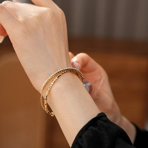 Macro view of gold-plated double-layer bracelet with white zircon pavé and geometric texture