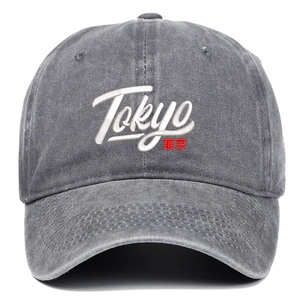 Detailed close-up of Tokyo embroidery on a washed grey cotton twill baseball cap