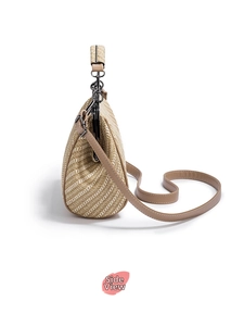 Detailed side view of beige woven handbag with brown leather strap and metal clasp