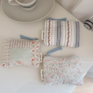 Detailed macro view of three quilted floral cotton mini pouches with zipper closure