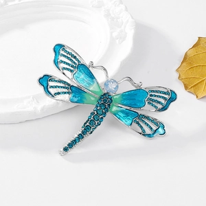Detail of dragonfly brooch with blue gradient wings and sparkling rhinestones