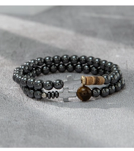 Detailed close-up of beaded cross bracelets with hematite, wood, and tiger eye stones