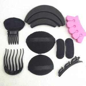 Macro shot of black sponge hair pads and plastic combs hair styling tools kit on white background