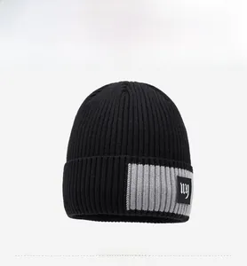 Detail einer schwarzen Strickmütze mit grauem Aufnäher und weißem NY-Stickmuster