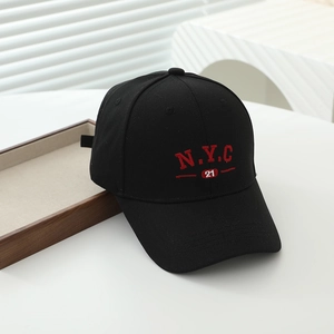 Detailed macro view of black cotton baseball cap with red NYC embroidery and vent holes