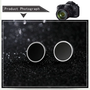 Macro shot of silver metal stud earrings with black matte inlay on a textured background