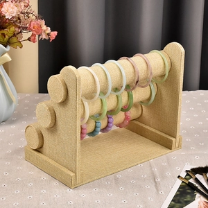 Three-tier linen jewelry display stand for organizing bracelets and watches with a sturdy base