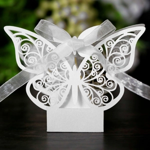 White laser-cut butterfly wedding favor box with pearlescent finish and ribbon