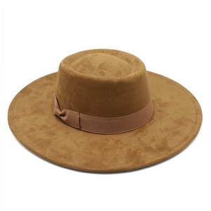 Détail du chapeau en suédine marron caramel avec un ruban décoratif à nœud élégant
