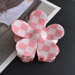 Close-up of pink and white checkered flower claw clip made of glossy acetate resin