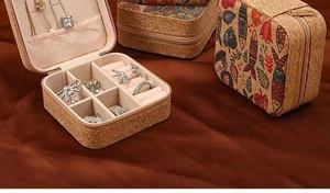 Detail of portable cork jewelry box featuring ring slots and soft pink velvet lining