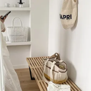 Close-up of cream canvas mommy bag with yellow base and functional outer pockets