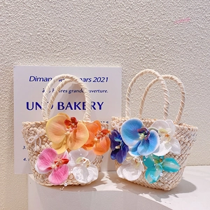 Handwoven straw tote bags with oversized orchid flowers and pearl accents for beach holidays