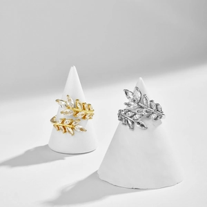Detail view of gold and silver leaf rings with marquise zircon on cone displays