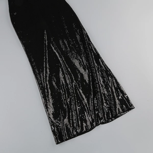 Detailed view of silver sequins in a wavy pattern on a black backless dress