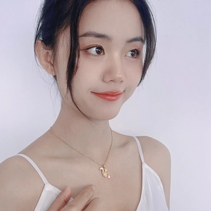 Golden squirrel necklace with pink crystal pendant worn by a model on white background