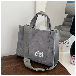 Detail of grey corduroy tote bag with adjustable strap and square white label