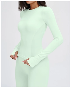 Detail eines nahtlosen Yoga-Langarm-Tops mit funktionellen Daumenlöchern in Minzgrün