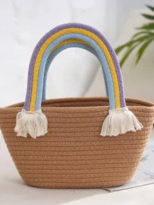 Handmade woven tote bag with rainbow handles and white cotton tassels in bohemian style