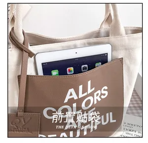 Close-up of canvas tote front leather pocket with lettering for tablet storage