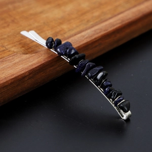 Detail of silver wavy hairpin featuring dark blue glittering natural crystal stones