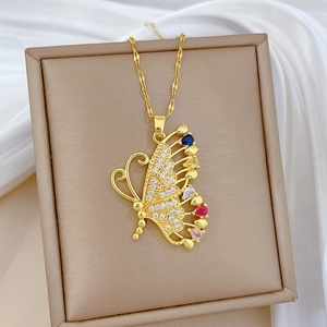 Macro view of gold butterfly pendant with colorful gemstones and crystals on silk fabric
