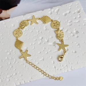 Close-up of 18K gold plated ocean charm bracelet with starfish and shell details