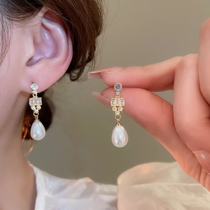 Detail of water drop pearl earrings with 18k gold plating and sparkling zircon stones