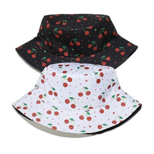 Detailed view of black and white bucket hats featuring vibrant red cherry and polka dot prints