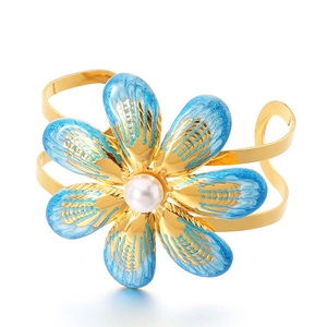 Golden double-layer open bangle featuring a blue enamel flower with a central pearl accent