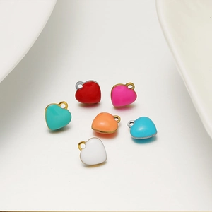 Primo piano di ciondoli a cuore colorati in toni macaron per la creazione di gioielli DIY