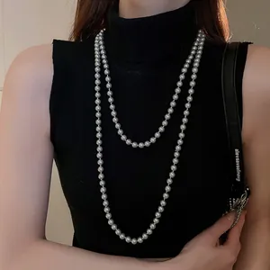 Detail view of gray double-layer pearl necklace with uniform 8-10mm pearls on black top