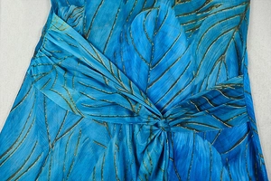 Detail of the blue leaf print dress showing the twisted knot design and fabric texture