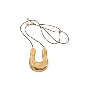 Collana minimalista con pendente a U dorato irregolare su un elegante cordino marrone