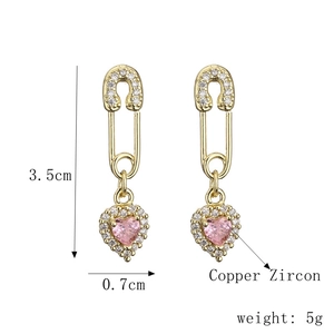 Détail macro de boucles d'oreilles cœur trombone avec zircon rose et dimensions de 3,5 cm