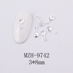 Gros plan de mini breloques clés 3x8mm en alliage argenté pour décoration d'ongles DIY