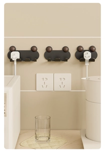 Wall-mounted black plug organizer hooks with wood accents shown in a kitchen setting