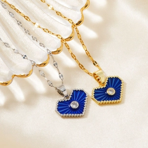 Detailed view of gold and silver heart necklaces with blue enamel and zircon center