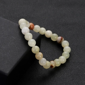 Macro view of a natural jade beaded bracelet on a premium black matte jewelry box