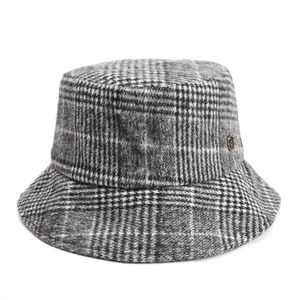 Detailed macro view of retro plaid wool bucket hat with small metallic logo tag on side
