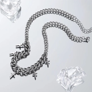 Cross pendant Cuban link necklace displayed on reflective surface with decorative ice cubes