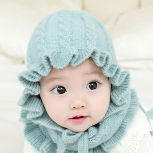 Winter knitted baby bonnet with ruffled edges and earflaps in soft mint green wool